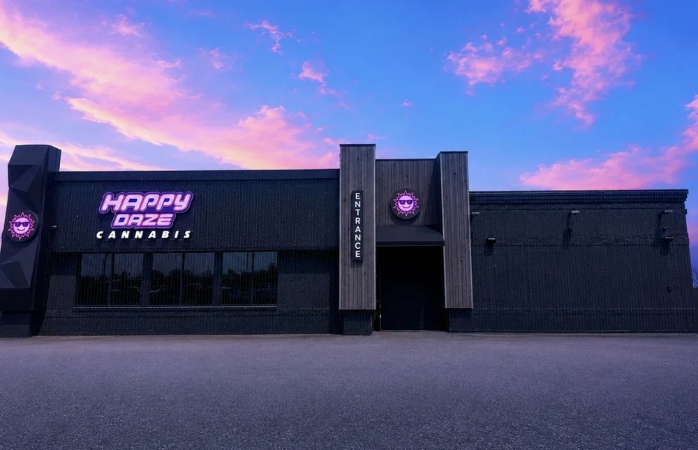Happy Daze Monroe dispensary exterior beneath a pink-and-blue evening sky
